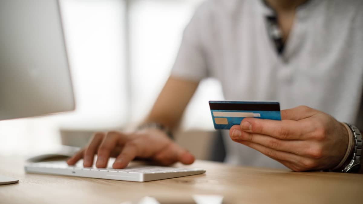 Homme tenant une carte bancaire pour réaliser un prélèvement