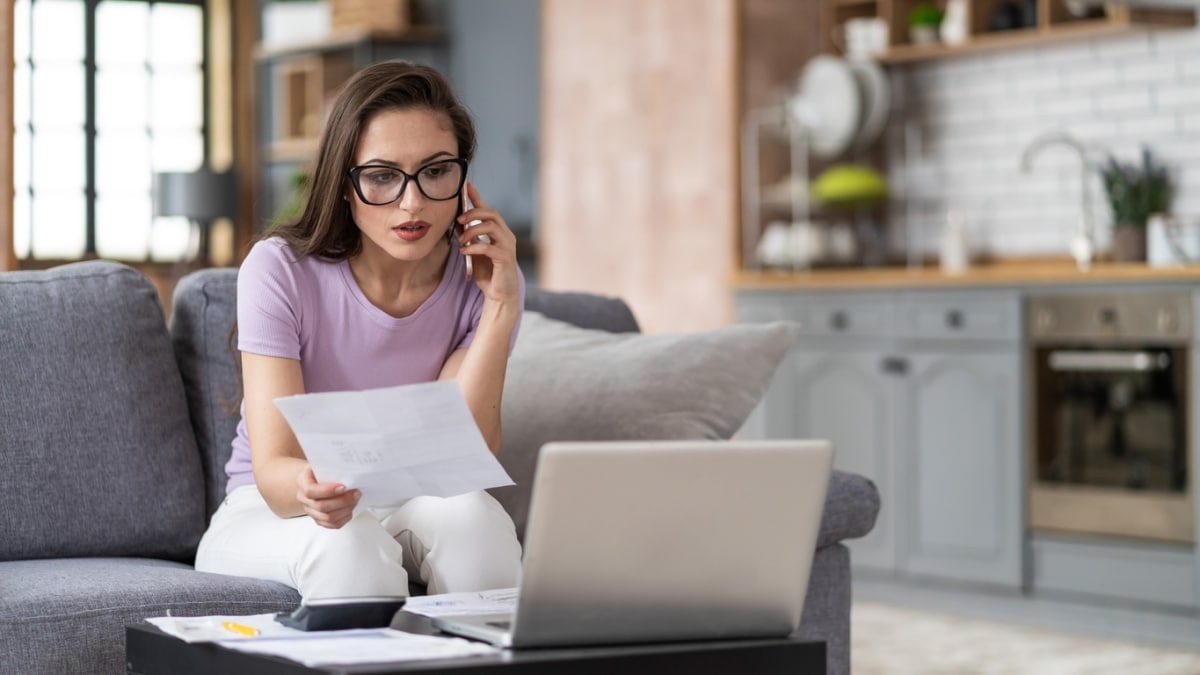 Une femme au téléphone devant son ordinateur