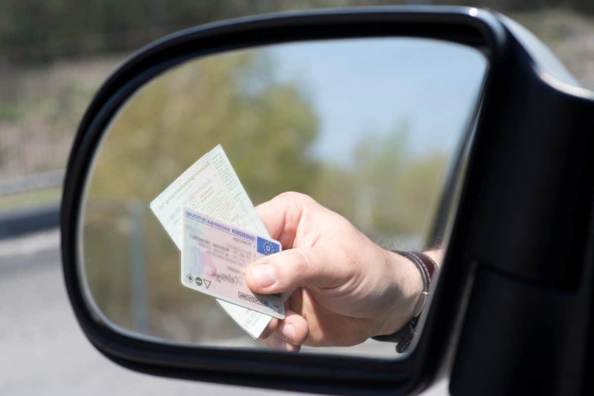 Un automobiliste présentant son permis de conduire.